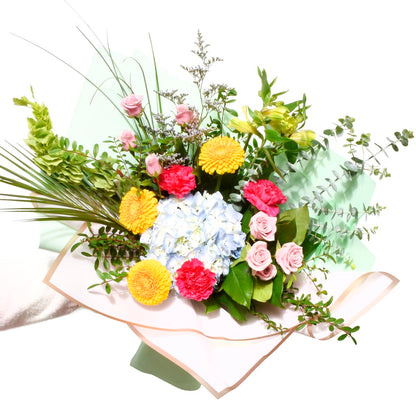 Bouquet of flowers with greenery on a white background, very colourful in yellow, pinks and blues.