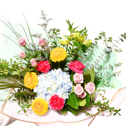Colorful bouquet of flowers with pink roses, yellow chrysanthemums, and greenery on a white background for a birthday in Burnaby BC